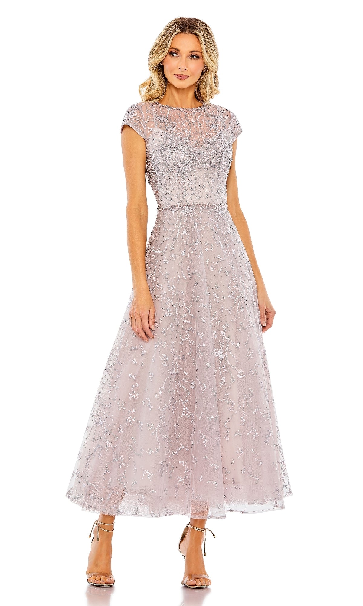 A woman wears the Mac Duggal 20338 Tea Length Lilac Party Dress, featuring intricate embroidery, paired with strappy high-heeled sandals.